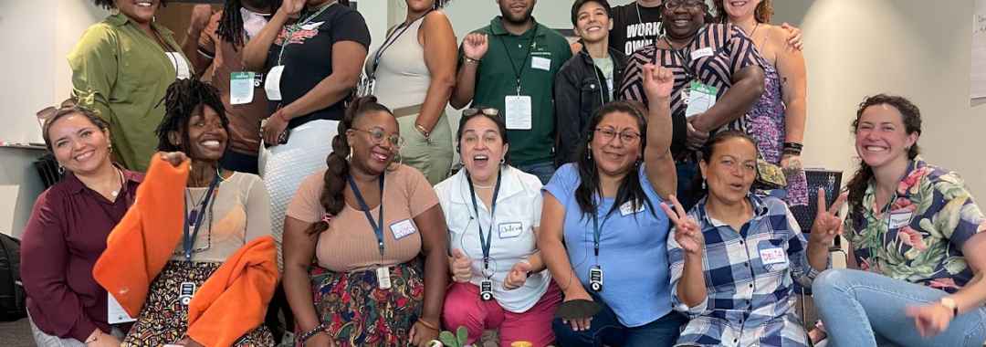 A group of fifteen individuals of different races and genders pose joyfully