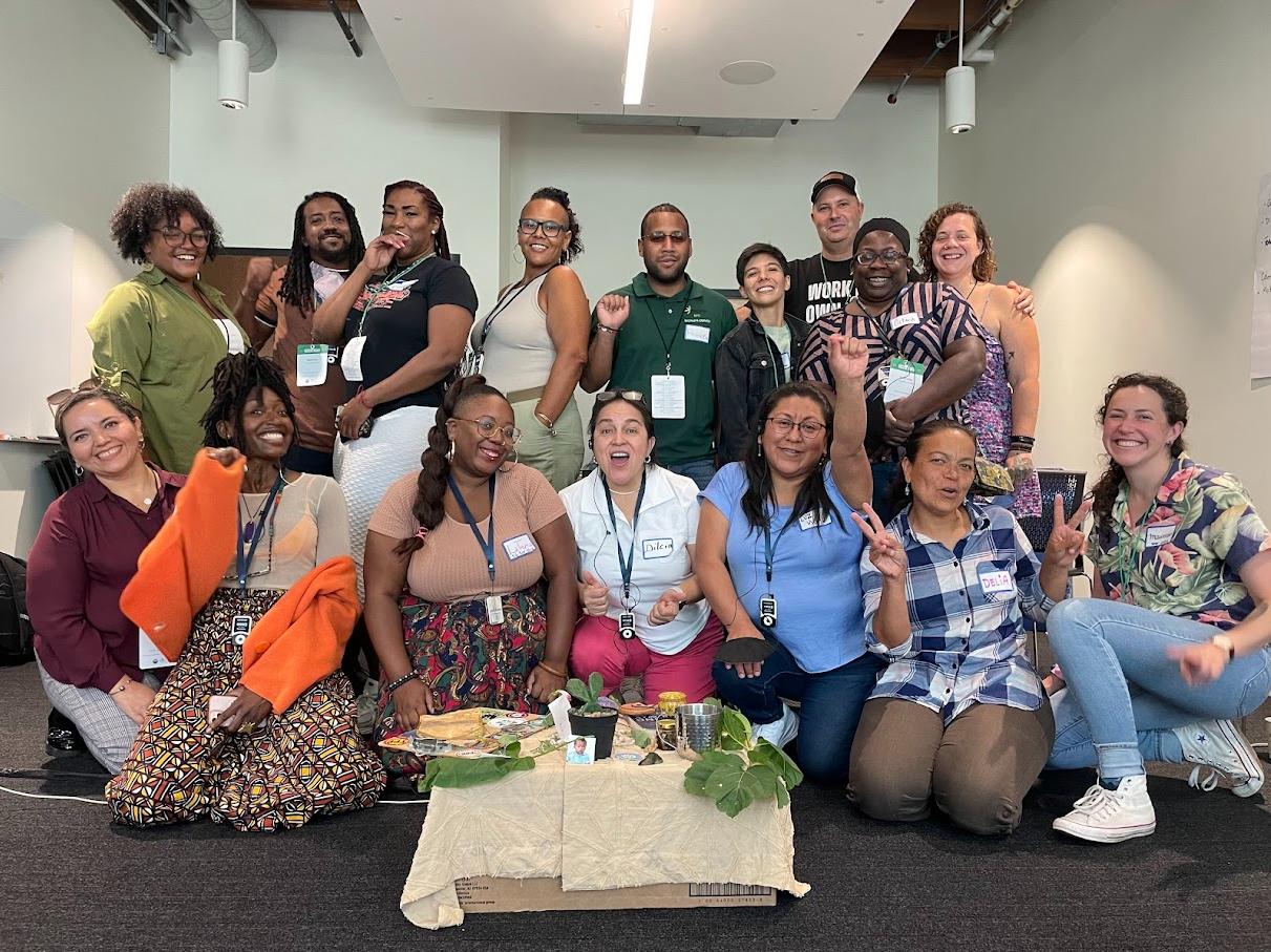 A group of fifteen individuals of different races and genders pose joyfully